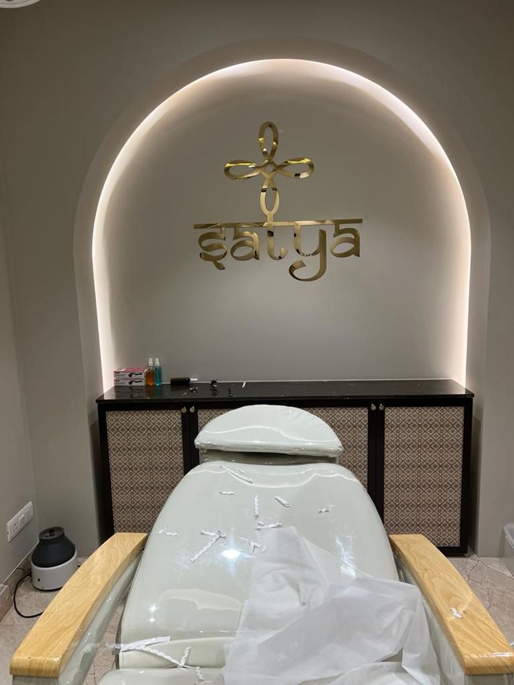 Treatment room with a backlit arched niche and gilded clinic emblem